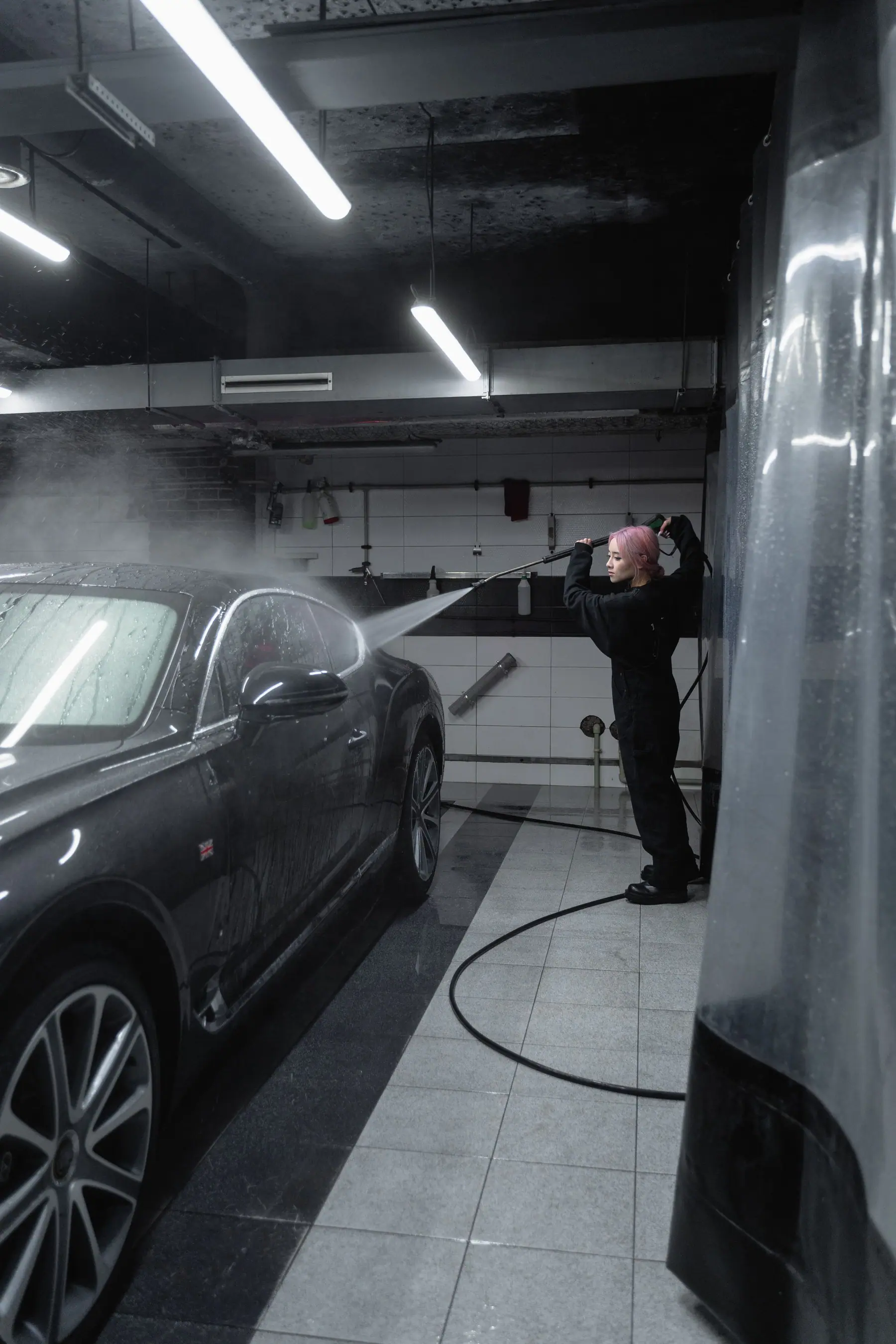 Wash partner cleaning a car with a pressure washer